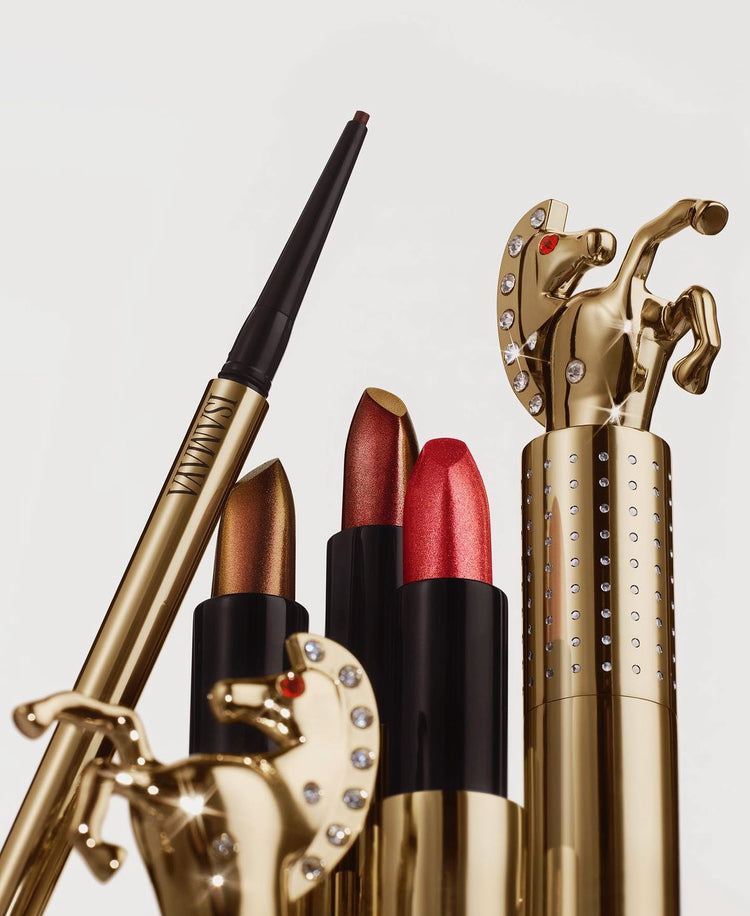 A collection of luxurious isamaya beauty lip products featuring three vibrant lipsticks in sleek gold tubes and a coordinating lip liner, adorned with a horse motif.
