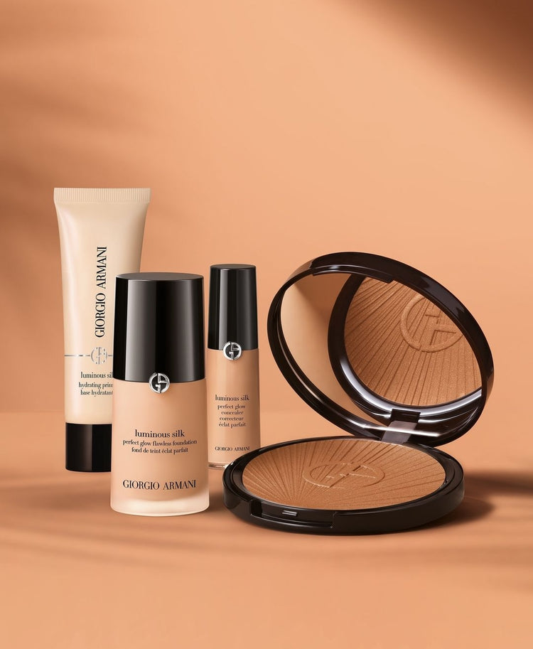 Collection of Giorgio Armani Beauty Luminous Silk makeup products, including foundation, concealer, base, and bronzer, elegantly displayed.