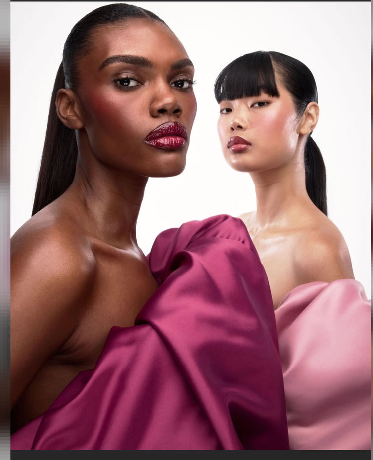 Two women are posing confidently and showing off the looks of Patrick Ta makeup products.