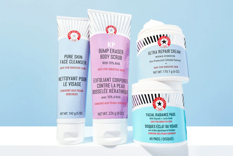 Four First Aid Beauty products: Pure Skin Face Cleanser, KP Bump Eraser Body Scrub, Ultra Repair Cream, and Facial Radiance Pads.