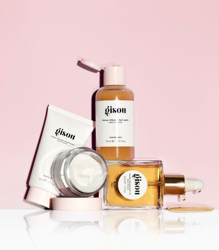 Gisou hair care products featuring honey-infused shampoo, conditioner, hair oil, and a cream