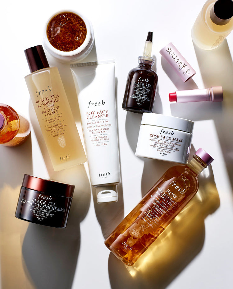 A flatlay of Fresh skincare products, including cleansers, masks, and serums, displayed on a bright surface.