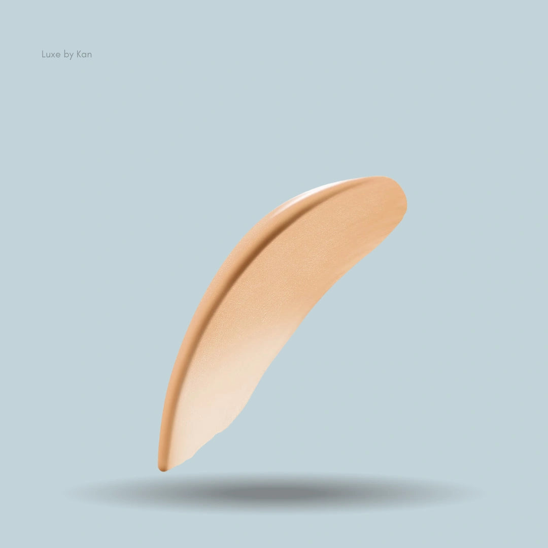 Armani Luminous Silk concealer swatch in a crescent shape on a solid light blue background, casting a soft shadow.