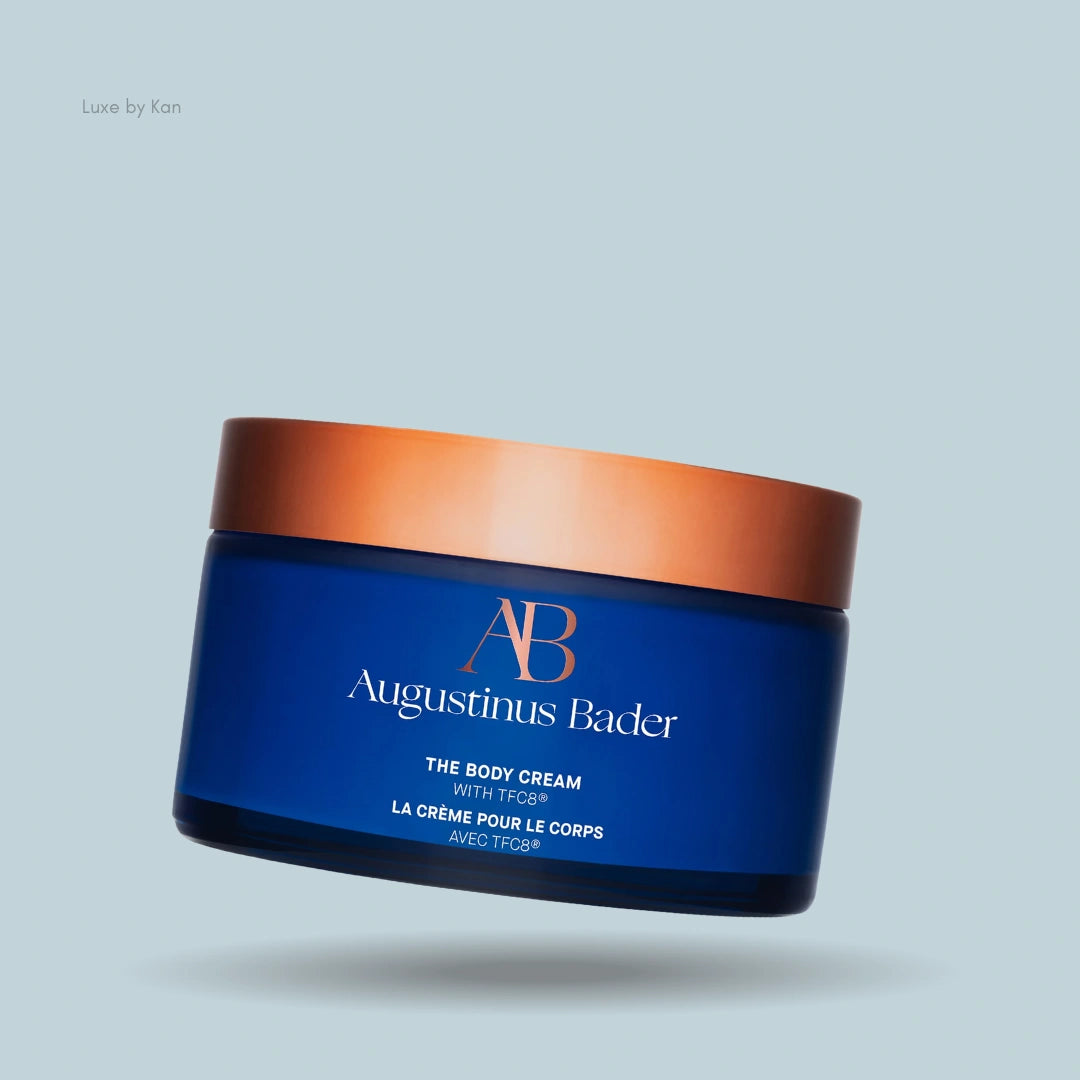Augustinus Bader The Body Cream in a dark blue jar with a copper-colored lid.