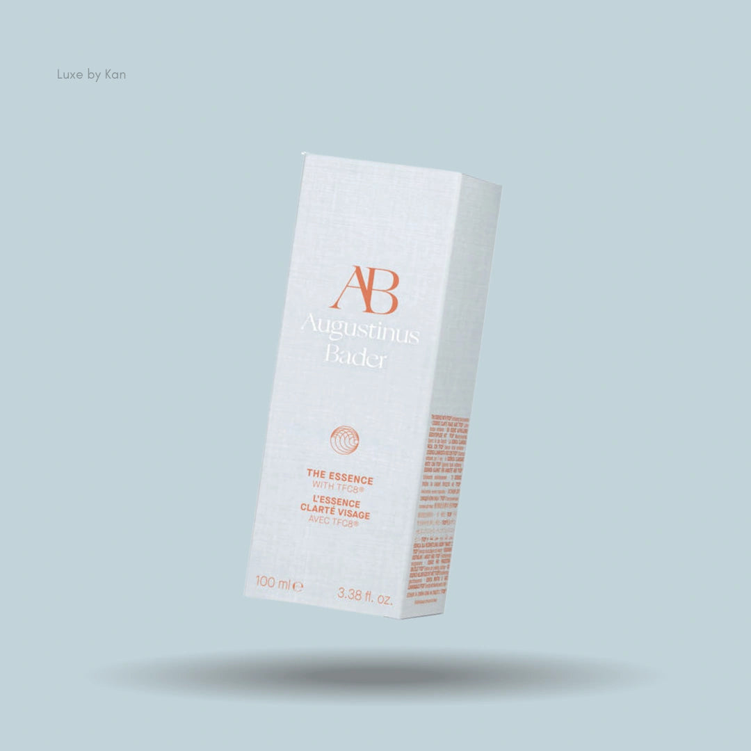 Augustinus Bader "The Essence" product box with minimalist white design against light blue backdrop.