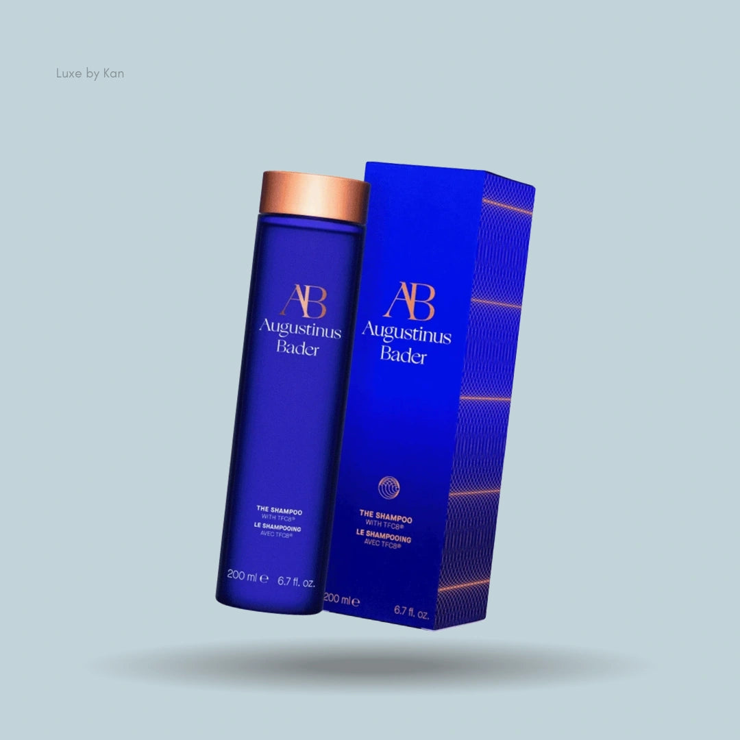 Augustinus Bader Shampoo bottle and box in signature blue with copper accents.