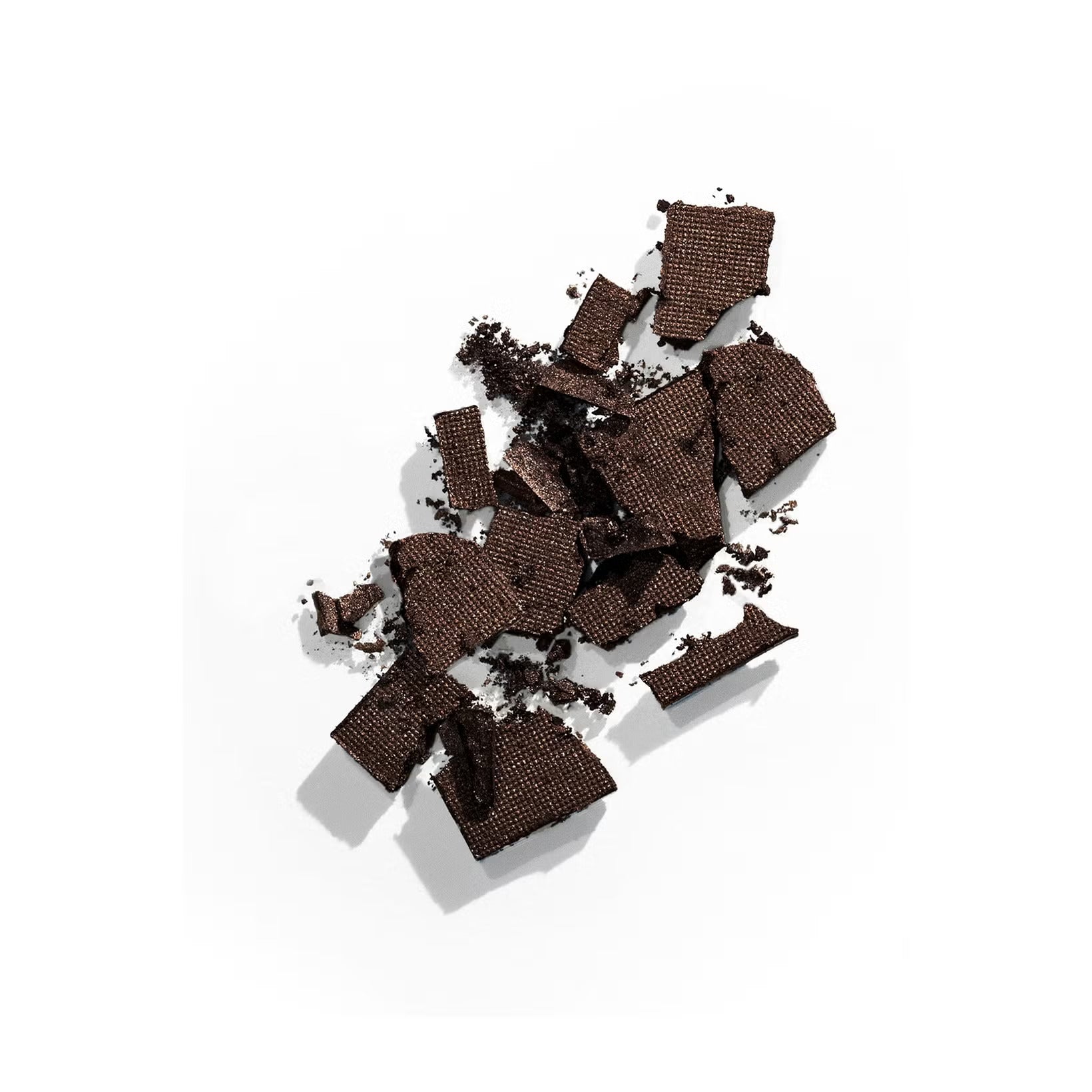 A scattered pile of dark chocolate squares and shavings on a white background, showcasing a rich texture and color.