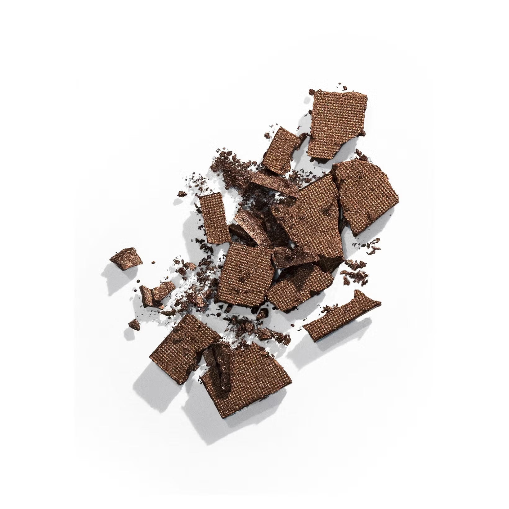 Cracked pieces of dark chocolate scattered with small shards and cocoa dust.