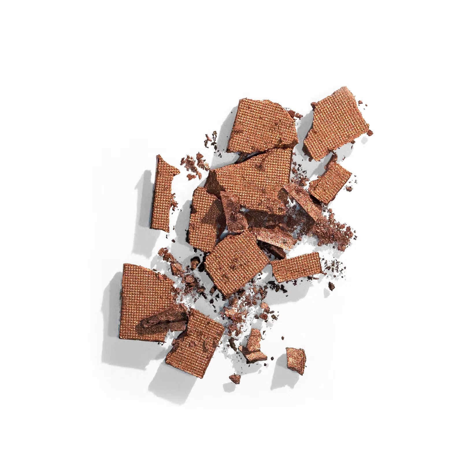 A pile of broken chocolate wafers scattered on a white surface, showcasing their textured surfaces and rich brown color.