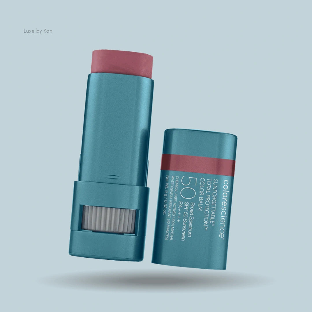 Colorescience Sunforgettable Total Protection Color Balm SPF 50 in a teal tube with a crimson balm extended beyond the applicator; the product's cap is off.