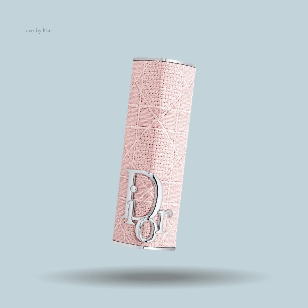 Close-up of a pale pink Dior Addict lipstick case, decorated with a quilted pattern and silver "Dior" logo.