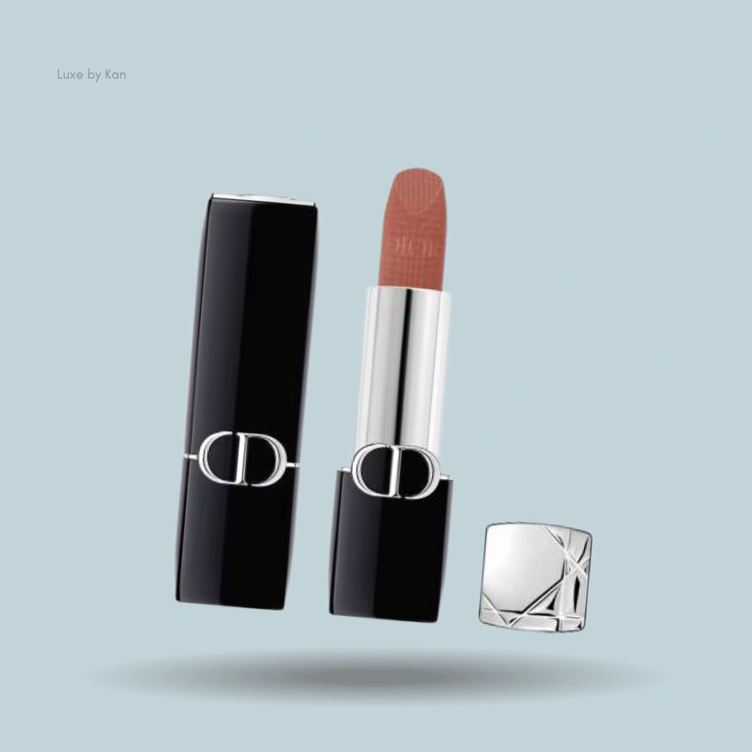Dior Rouge New Velvet Lipstick in sleek black and silver packaging, featuring an exposed warm brown shade with a soft matte finish.