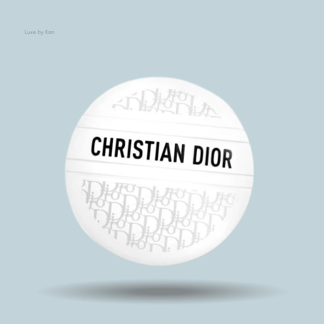 A white, spherical Dior balm container with "CHRISTIAN DIOR" printed horizontally across the center.