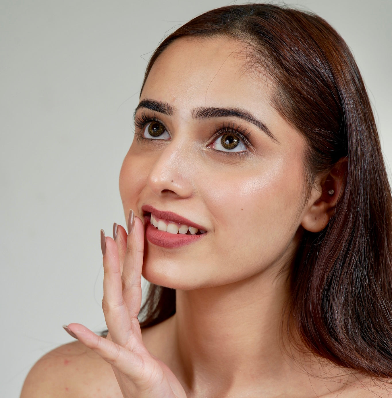 A woman touching her lips and showcasing the beauty of the Roman Empire Velvet Liquid Matte Lipstick shade.