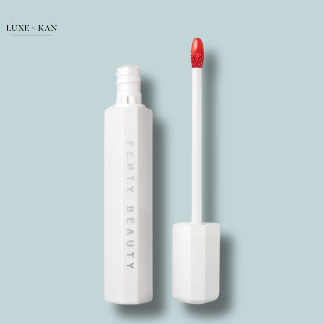An open Fenty Beauty Poutsicle Hydrating Lip Stain tube and its applicator with a bright red tip on the doe foot.