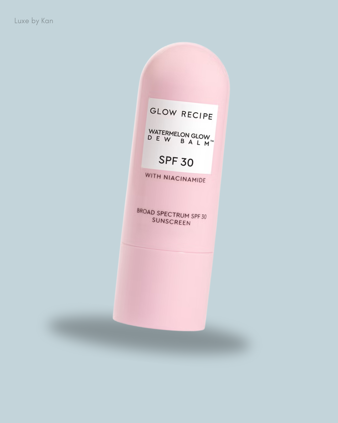 A pink bottle of Glow Recipe Watermelon Glow Dew Balm SPF 30 with niacinamide, designed for sun protection and hydration.