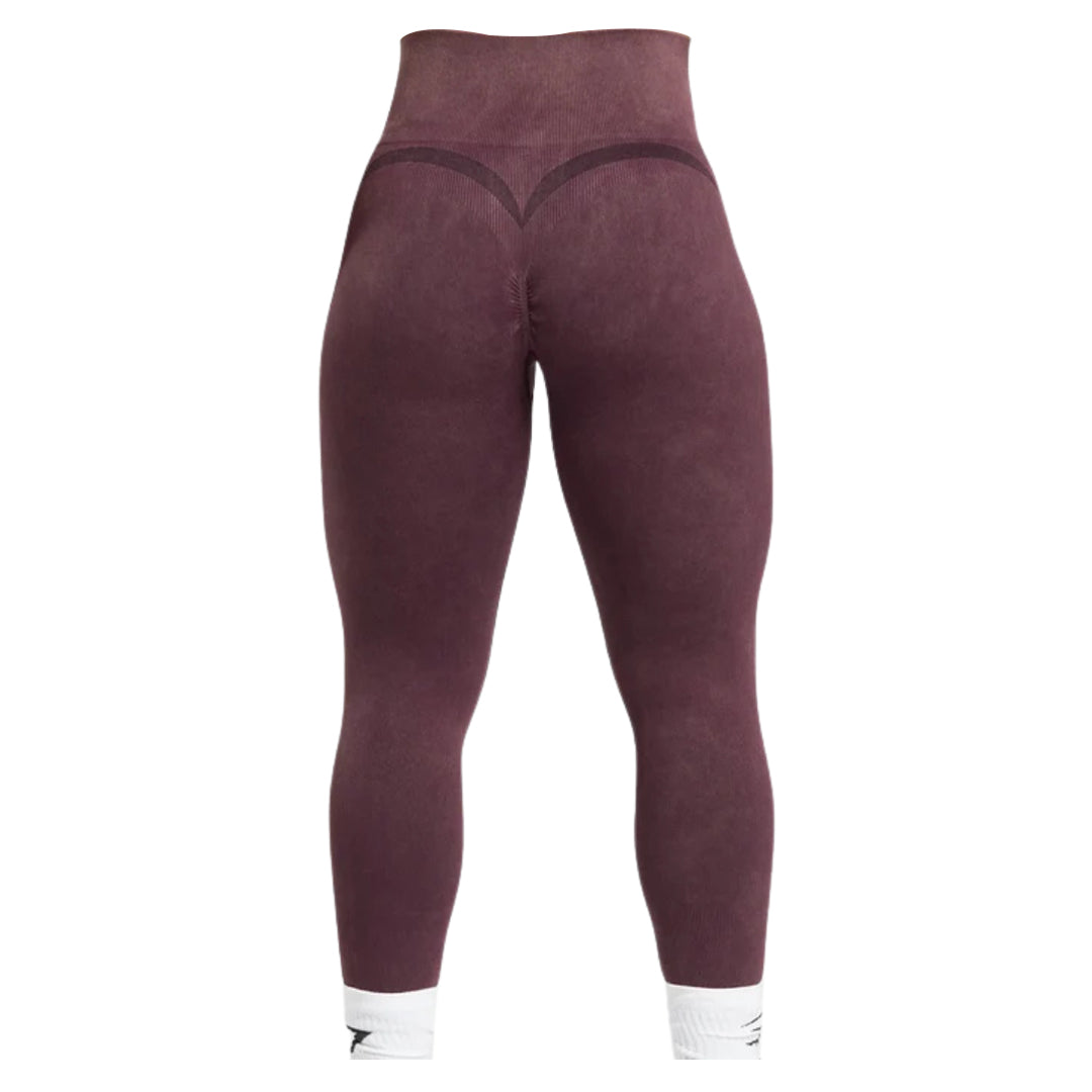 Back view of dark mauve Gymshark Gains Seamless Leggings featuring a high waistband, heart-shaped detailing at the top of the glutes, a white athletic logo, and white ribbed ankle cuffs.