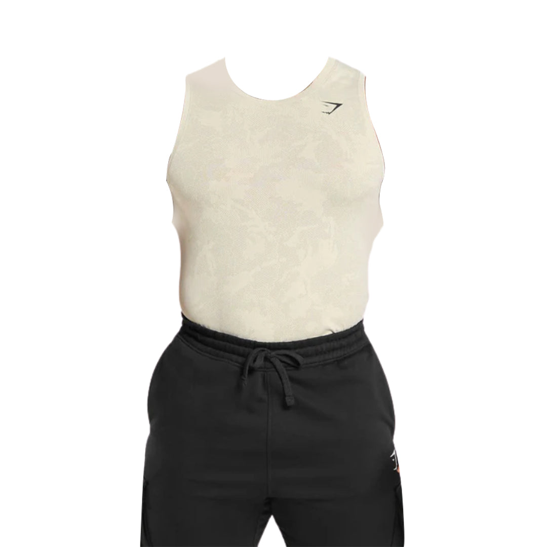 Cream-colored sleeveless top paired with black joggers, featuring a subtle pattern and a logo on the chest.