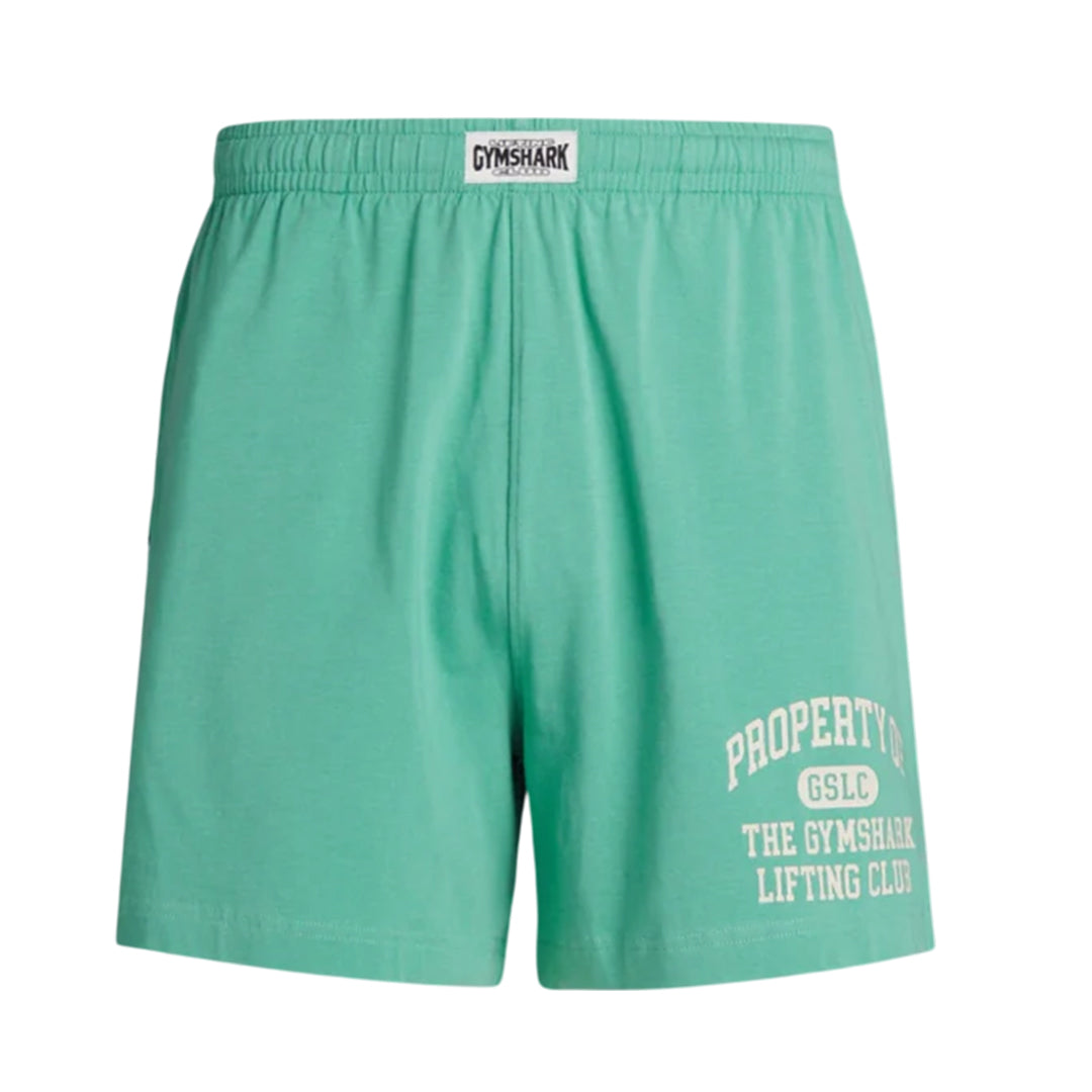 Men's Gymshark lightweight jersey shorts in light green, featuring an elastic waistband with Gymshark logo and "Property of GSLC The Gymshark Lifting Club" printed in white on the left leg.
