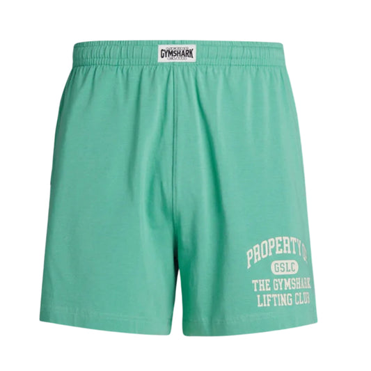 Men's Gymshark lightweight jersey shorts in light green, featuring an elastic waistband with Gymshark logo and "Property of GSLC The Gymshark Lifting Club" printed in white on the left leg.