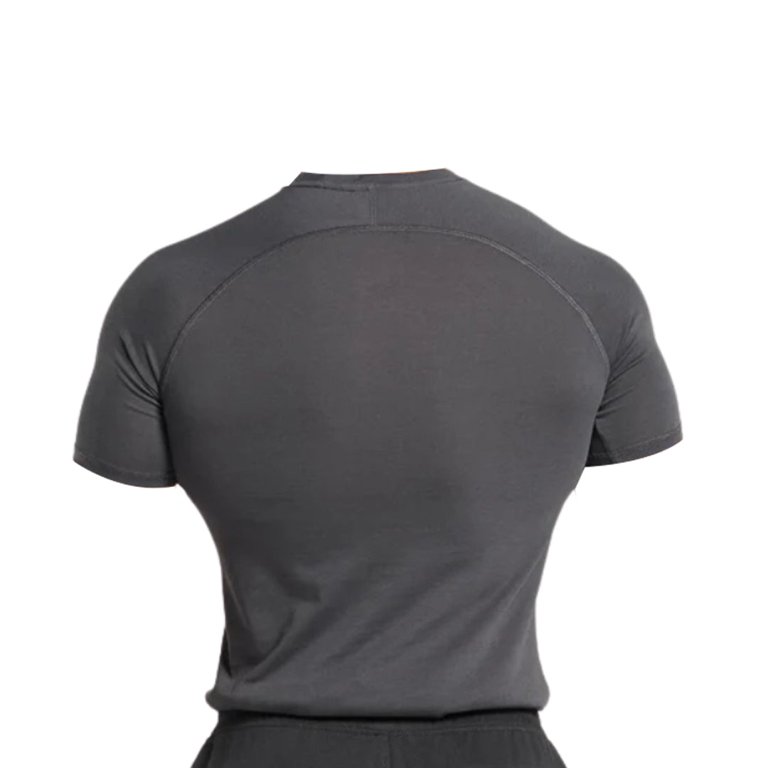 A man wearing a fitted dark gray athletic shirt, viewed from the back, showcasing its sleek design and shoulder seams.