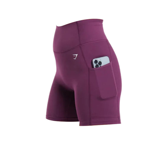 Maroon Gymshark Body Fit Pocket Shorts featuring a high waistband, streamlined silhouette, and a side pocket holding a smartphone, with a white logo visible near the hip.