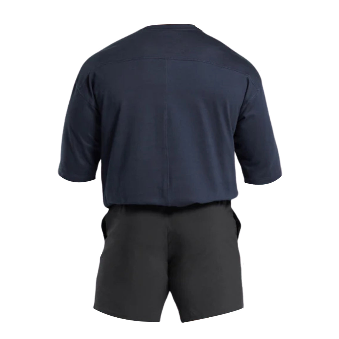 Back view of a casual navy blue short-sleeve shirt paired with black shorts, showcasing comfortable, relaxed-fit style.