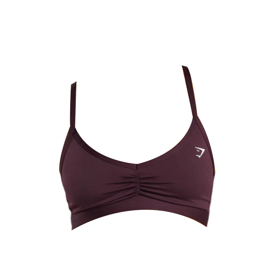 Hot pink sports bra with adjustable straps and gathered detailing at the front, featuring a small white logo on the side.