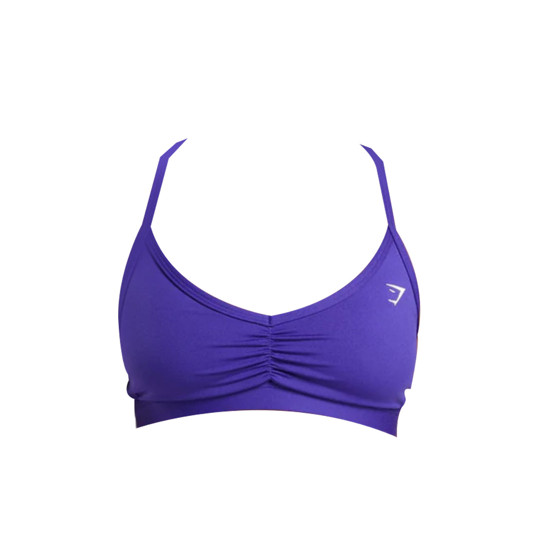 Blue sports bra with adjustable straps and gathered front detailing, featuring a small logo on the left side.