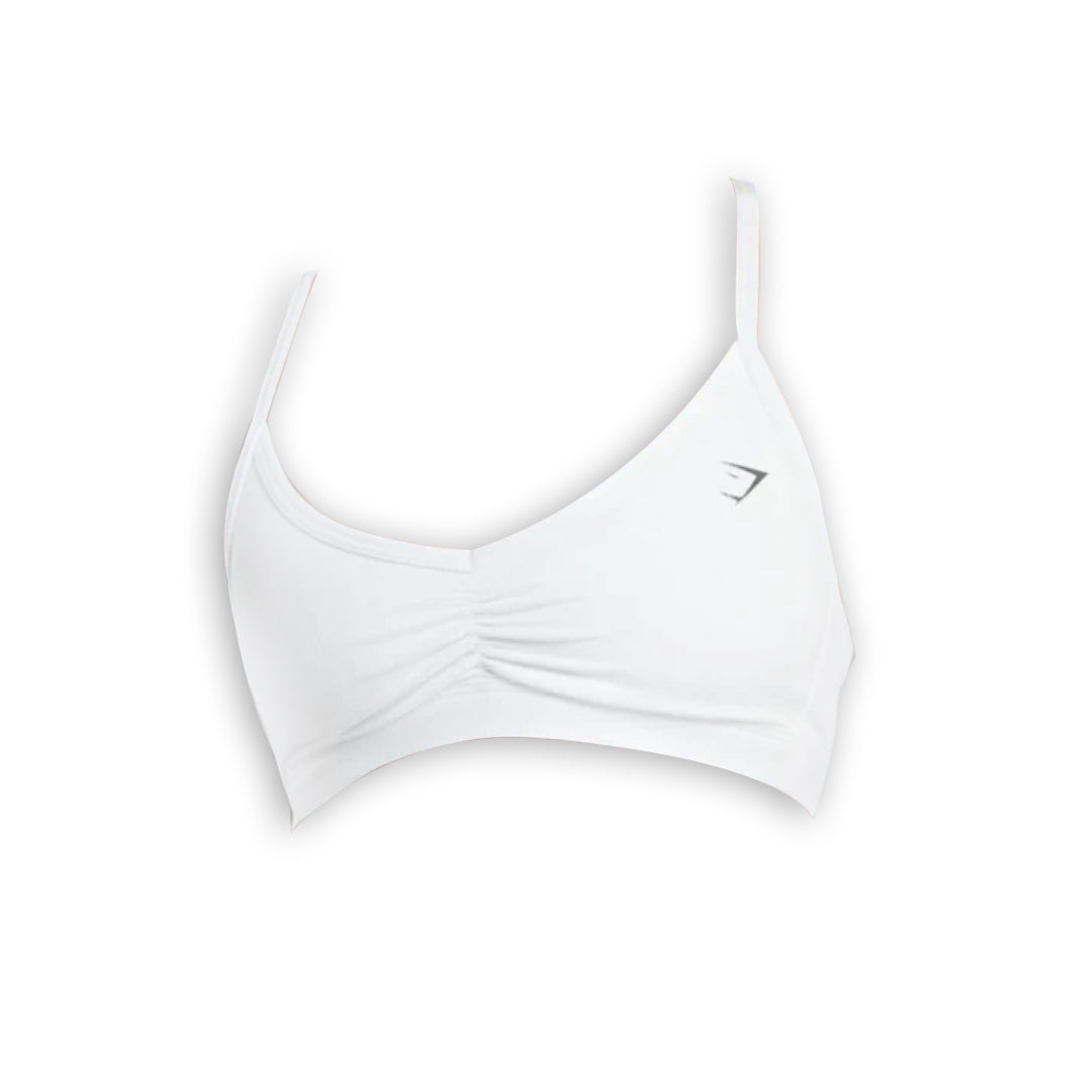 White sports bra with a sleek design and ruched detail, featuring adjustable straps and a logo on the left side.