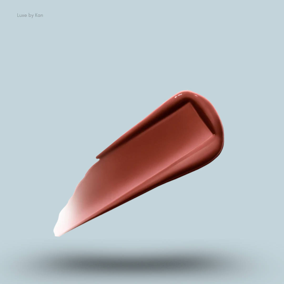 A glossy swatch of the deep rosy-brown shade 'Rouse' of the Hourglass Phantom Volumizing Glossy Lip Balm on a pale blue background.