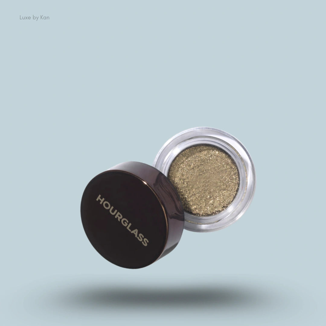 Hourglass Scattered Light glitter eyeshadow with vivid glitter shade inside, with a brown round cap next to it.