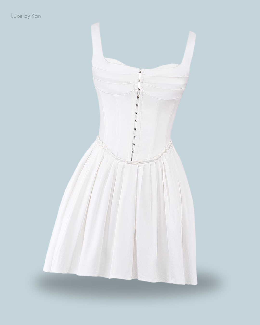 A stylish white cupid pleated mini dress with a fitted bodice, buttons down the front, and a pleated skirt.