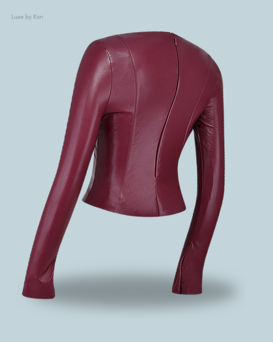 A stylish House of CB burgundy vegan leather jacket featuring long sleeves and a sleek zip closure at the back.