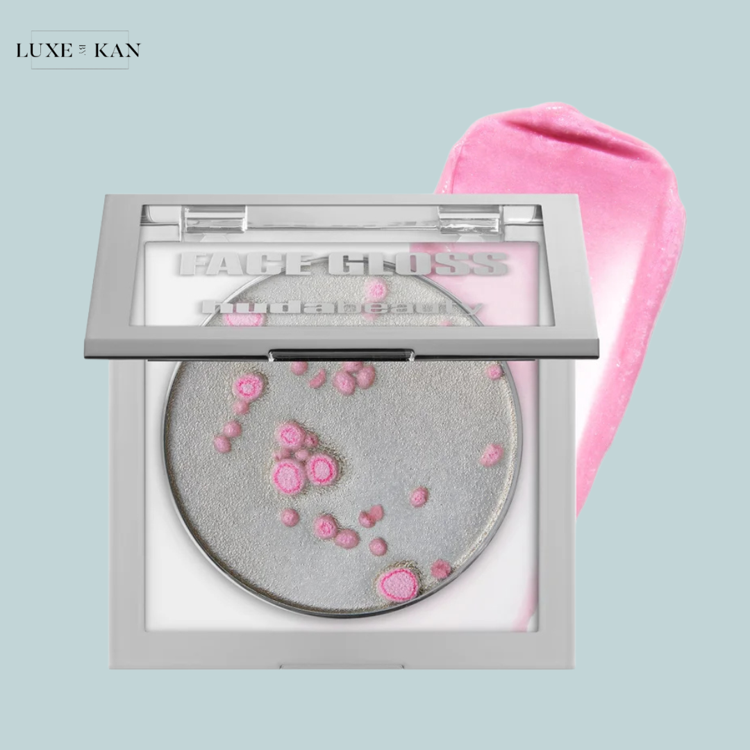 A stylish compact of huda beauty icy nude ph face gloss featuring a shimmering silver powder with pink accents and a pink applicator swatch.