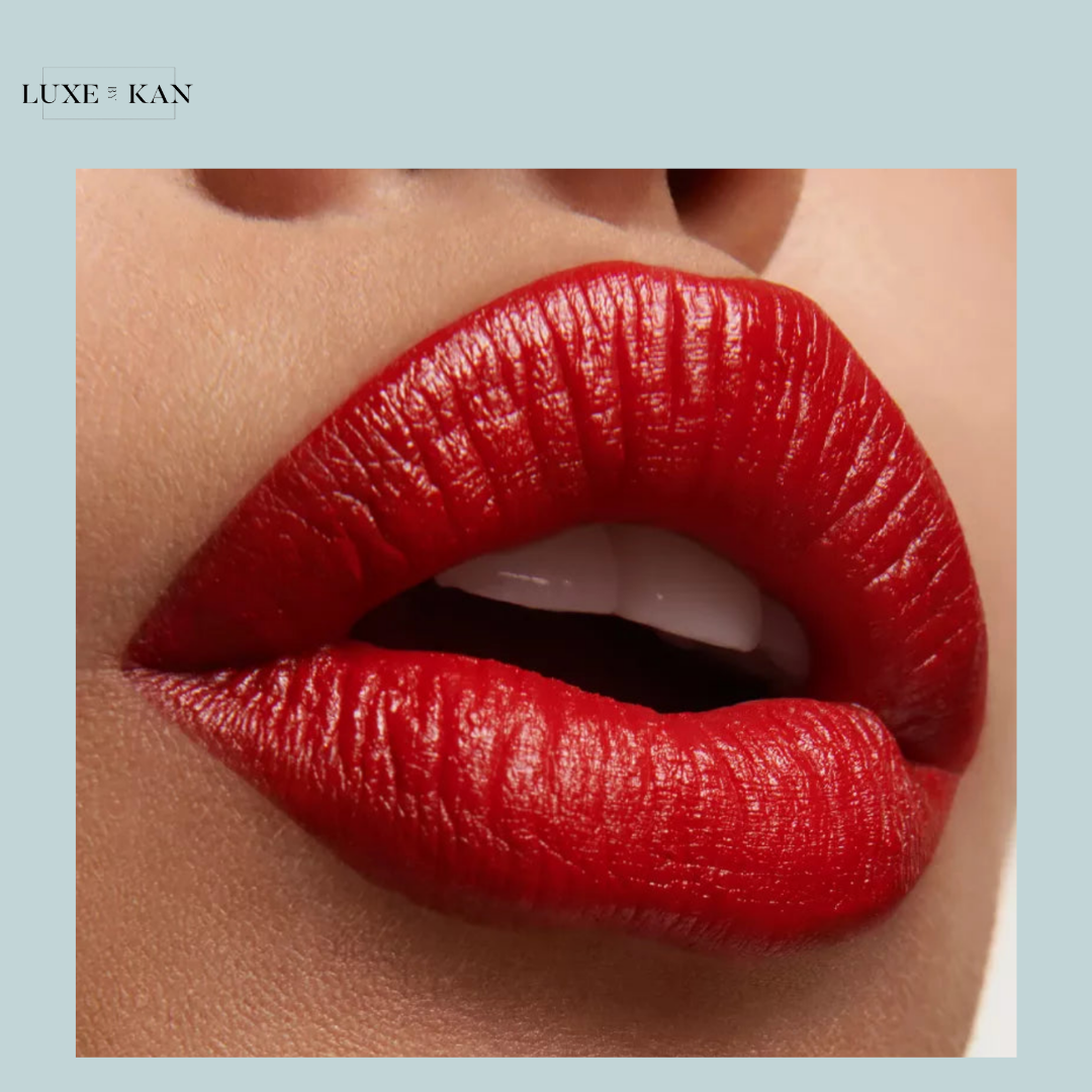 Close-up of luscious lips coated in glossy red lipstick against a neutral background, showcasing a vibrant, bold makeup look.
