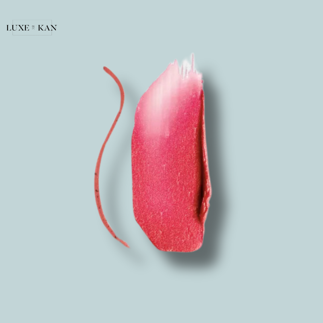 Close-up of a vibrant pink lipstick swipe beside a matching lip liner on a soft blue background, showcasing a beauty product from Luxe by Kan.