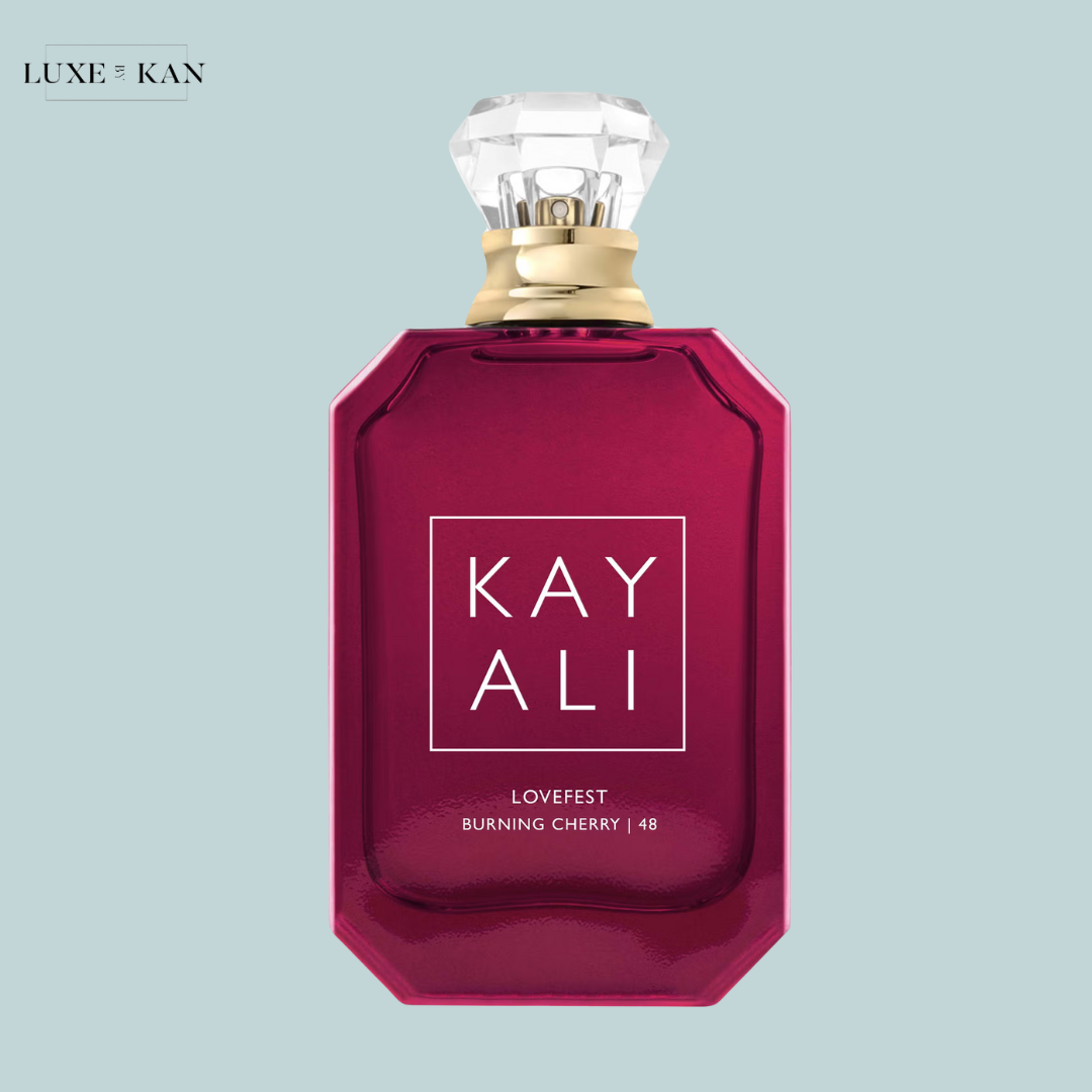 A rich, octagonal perfume bottle in deep red with a diamond-shaped cap, labeled "KAY ALI LOVEFEST BURNING CHERRY | 48."