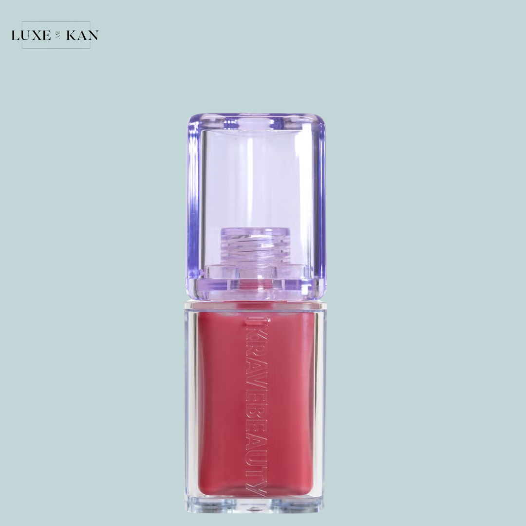 A sleek, transparent bottle of Plumpuscious Lip Jelly with a lavender cap, labeled "KRAVE BEAUTY."