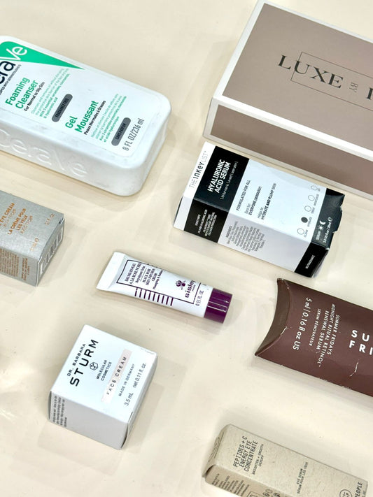 Flat lay of skincare products including cleansers, serums, and creams from brands like CeraVe, The Inkey List, and Dr. Barbara Sturm.