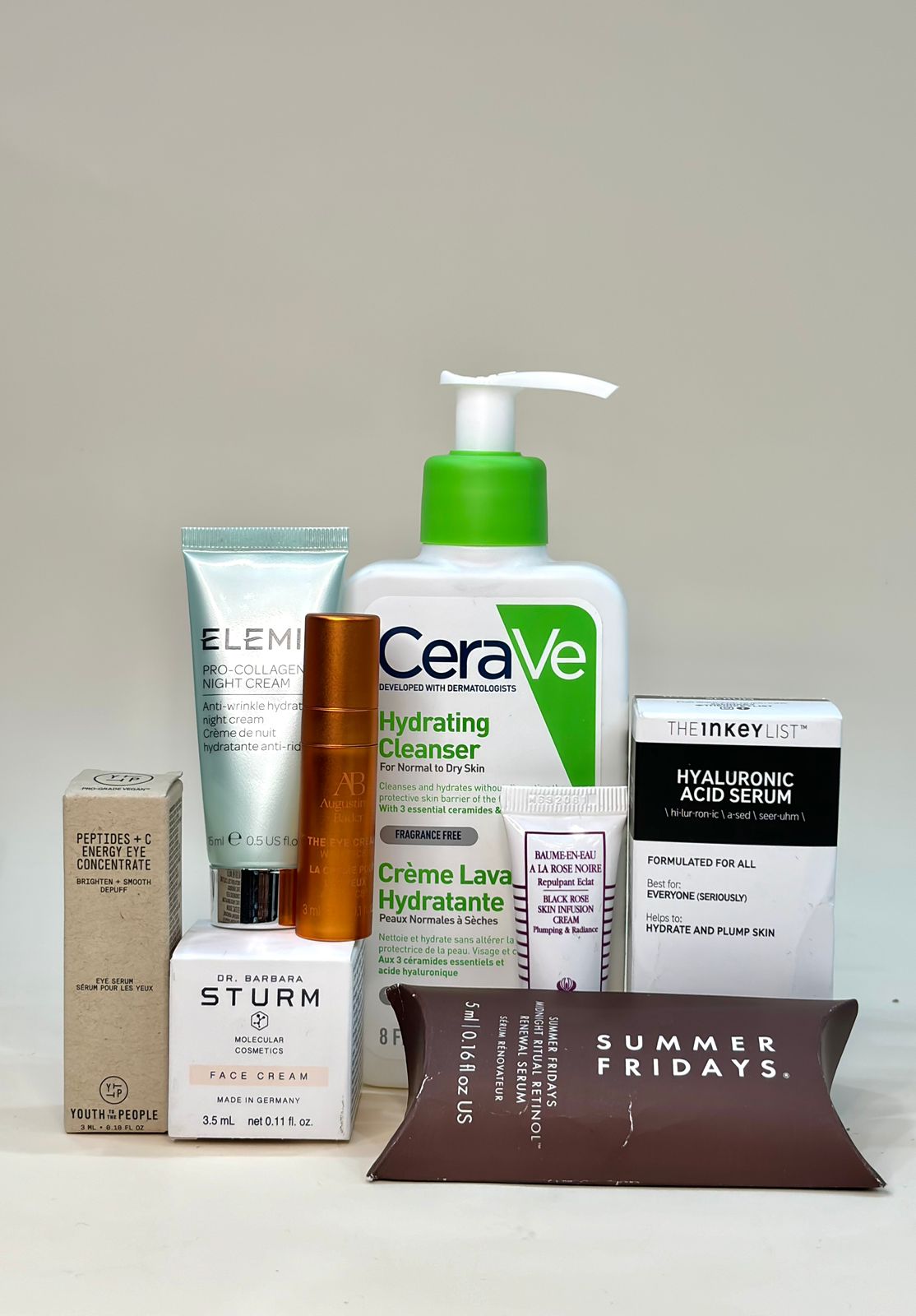 A collection of skincare products including cleansers, serums, and creams from brands like CeraVe, Elemis, and Summer Fridays, on a plain background.