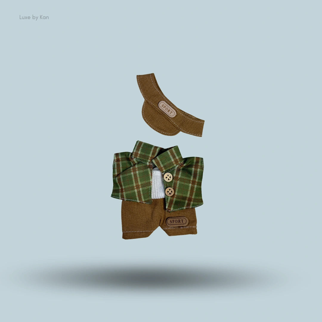 Labubu doll sports outfit: brown visor cap, green plaid jacket, gray golf shirt and brown shorts.