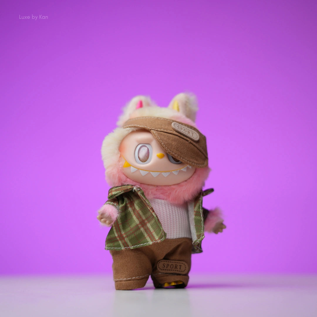 Labubu doll in brown mini golfer sport outfit and matching hat with a plaid jacket.
