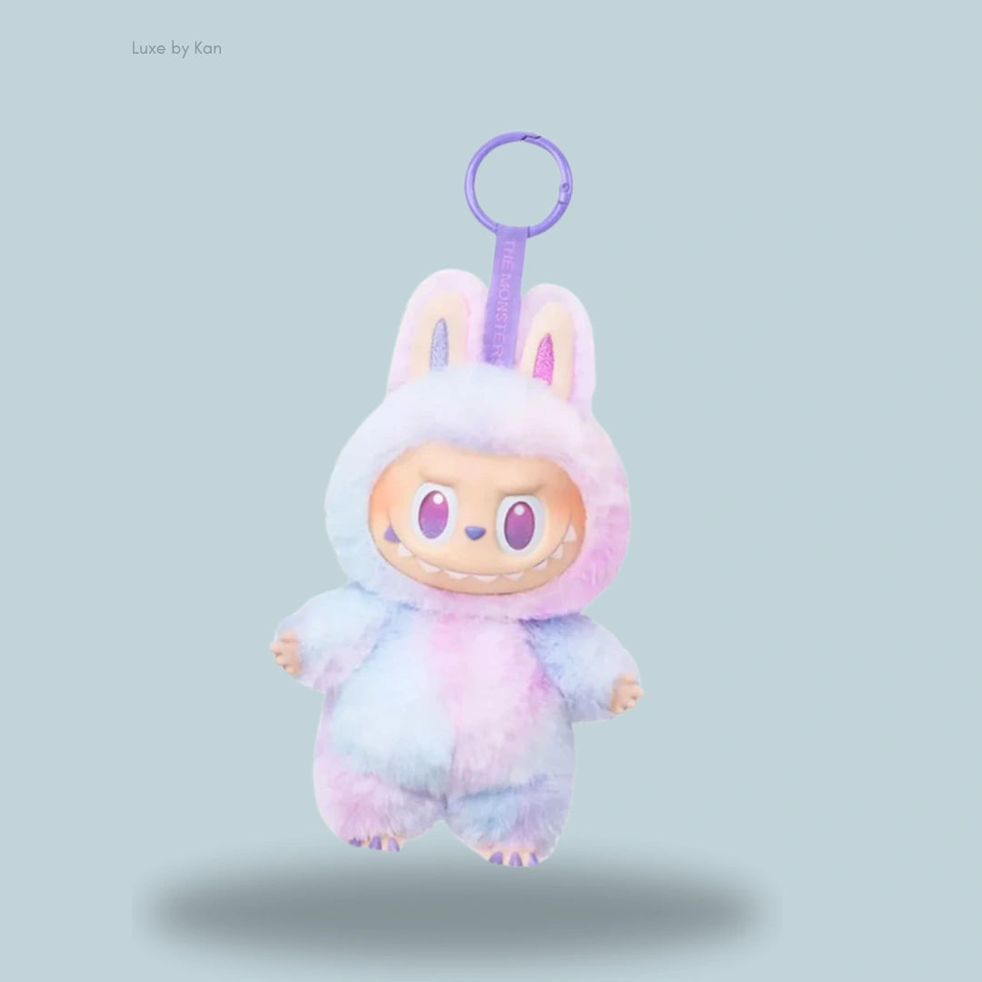 Labubu The Monsters Big Into Energy Series Luck Vinyl Plush Pendant – A fluffy pastel plush toy wearing a bunny costume, featuring large eyes and sharp teeth, hanging from a purple keyring.