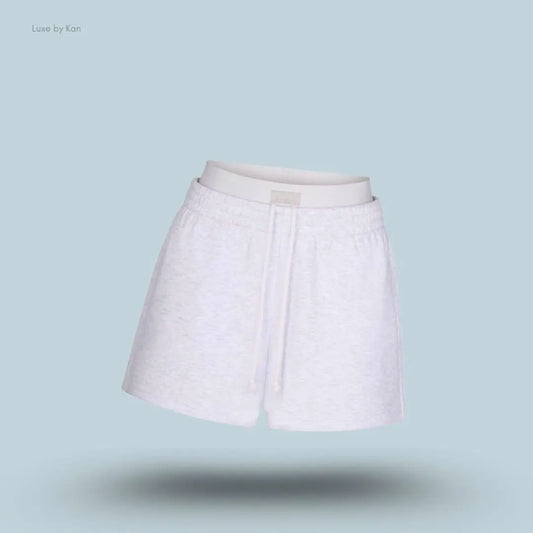 SKIMS Cotton Fleece Double Waistband Short in Light Heather Grey, flat lay on light blue background