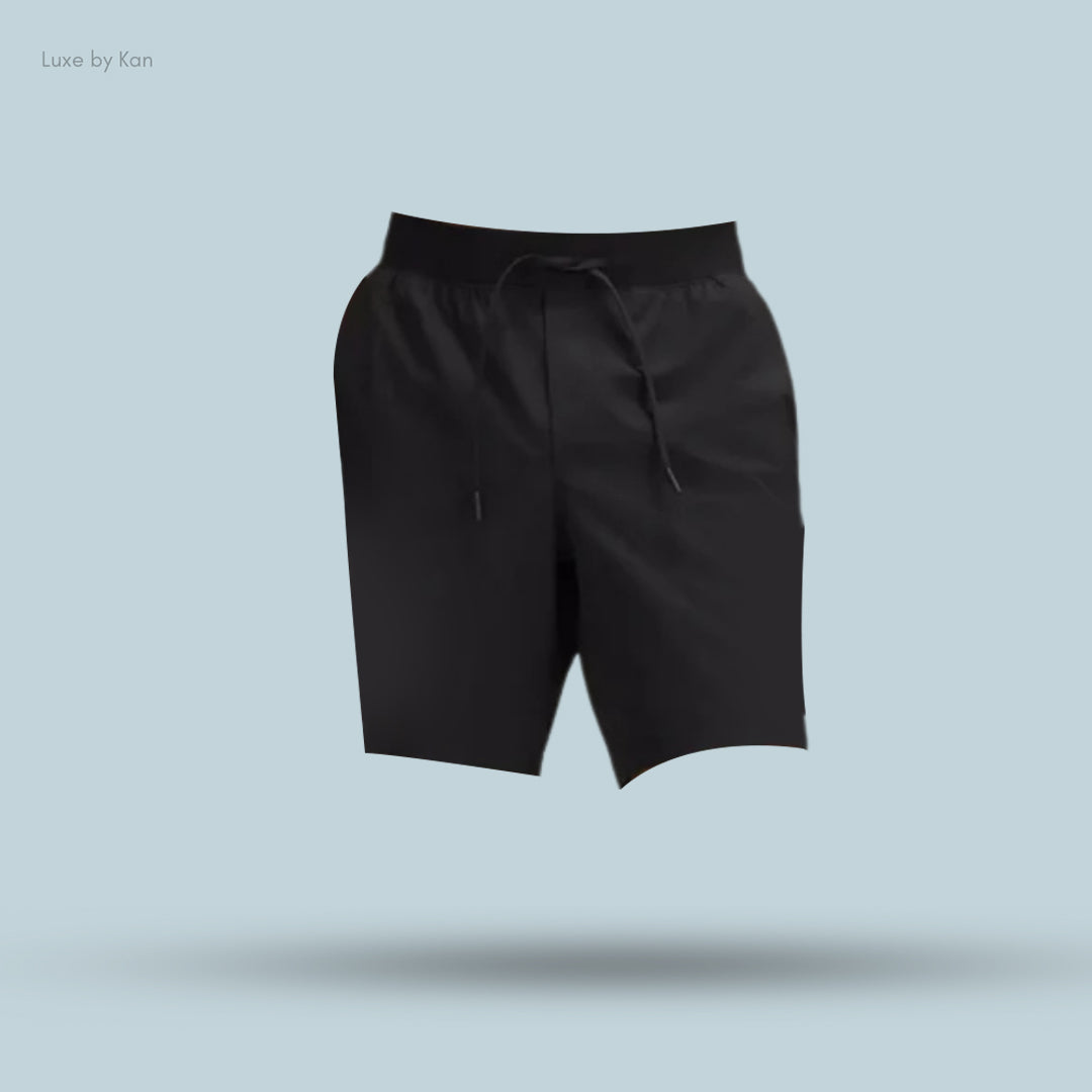 Black drawstring shorts displayed against a soft blue background, featuring a relaxed fit and a modern design.