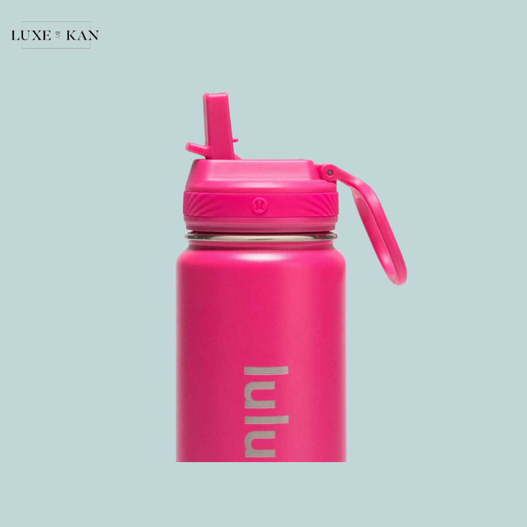 Bright pink water bottle with a silicone lid and spout, featuring the brand logo "lululemon" prominently displayed.
