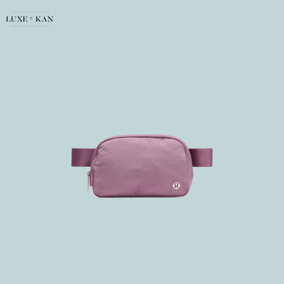 A stylish lavender fanny pack with a Lululemon logo, set against a light blue background. Perfect for casual outings and hands-free convenience.