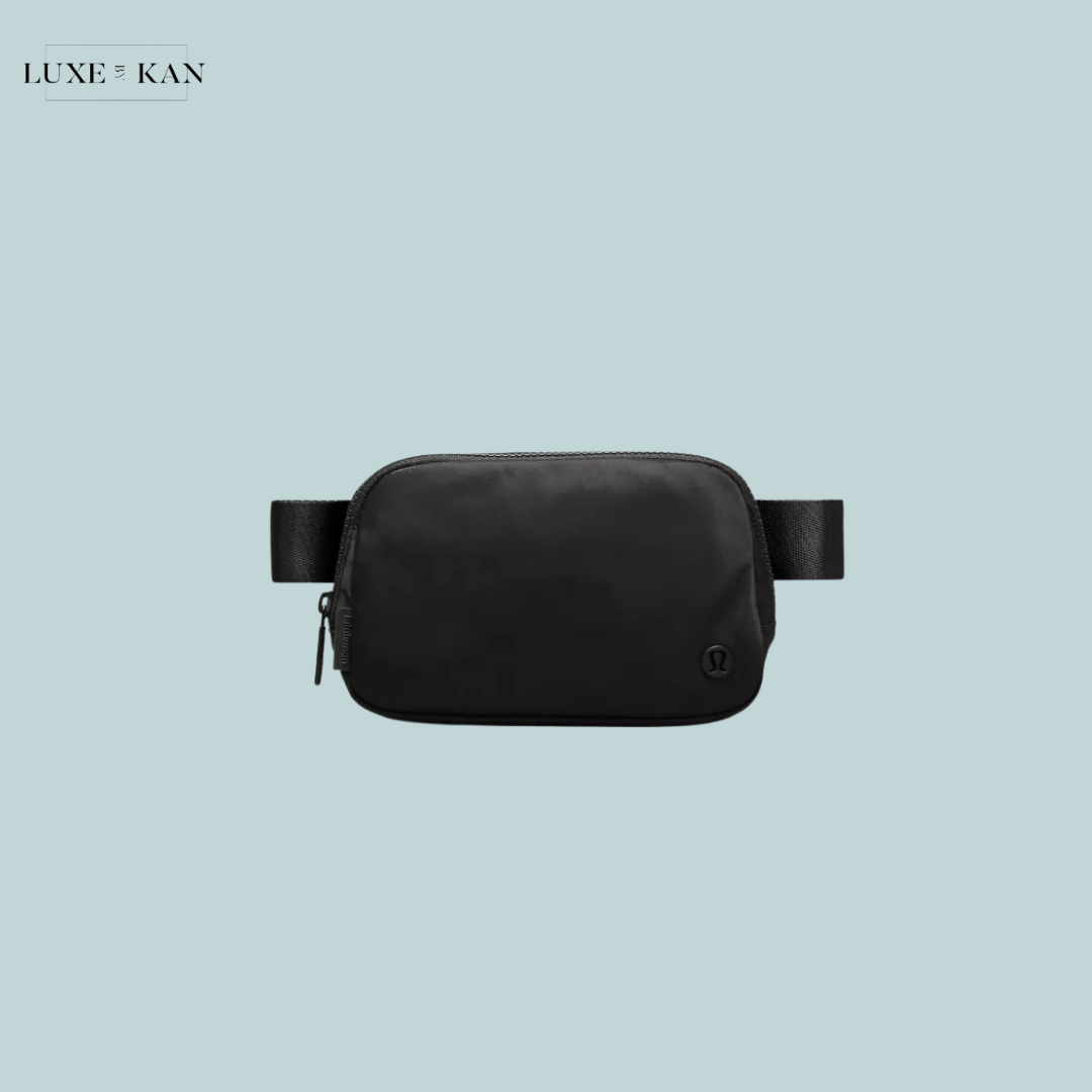 A sleek black waist bag with a zipper and adjustable strap.