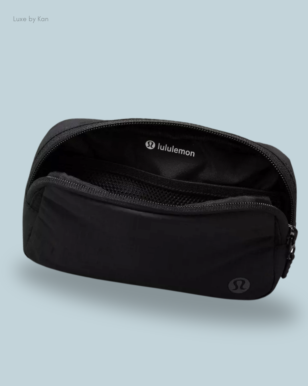 A sleek black Lululemon Everywhere Belt Bag Mini Ripstop, partially unzipped to reveal its interior mesh pocket.